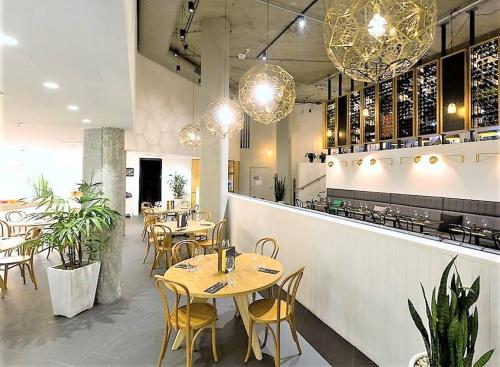 un restaurante con mesas y sillas y un bar en Song Hotel Sydney en Sídney