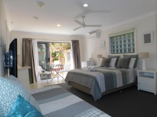 um quarto com uma cama e uma sala de estar com um pátio em Beachport Bed & Breakfast em Port Macquarie