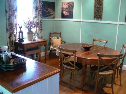 a dining room with a wooden table and chairs at Lemon Tree Cottage in Leura