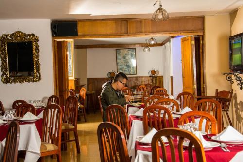 Ein Mann, der an einem Tisch in einem Restaurant sitzt. in der Unterkunft Hotel Chamana in Caicedonia