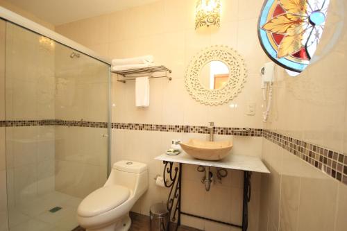 a bathroom with a toilet and a sink and a shower at Hotel Boutique Ponciano in Guanajuato
