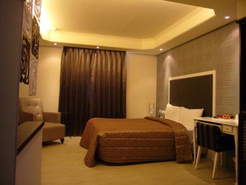 a hotel room with a bed and a desk at Windmill Fashion Hotel in Kaohsiung