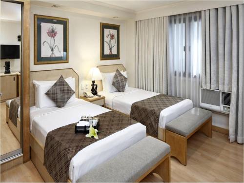 Postel nebo postele na pokoji v ubytování Manila Lotus Hotel