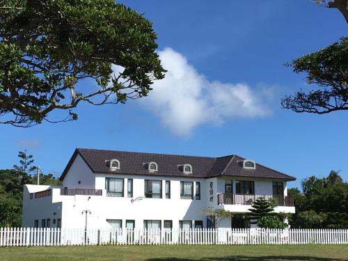a white house with a white picket fence at Summer Homestay in Kenting