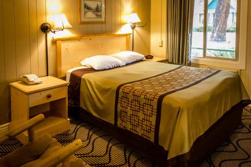 a hotel room with a bed and a telephone at Green Gables Motel & Suites in Burney