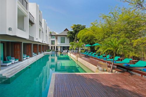 a swimming pool with blue chairs next to a building at The Serenity Hua Hin in Hua Hin