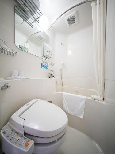 a white bathroom with a toilet and a sink at Natural Hot Spring Super Hotel Tottori Eki Kitaguchi in Tottori