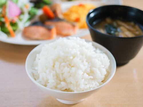 a bowl of rice on a table with a plate of food at Natural Hot Spring Super Hotel Tottori Eki Kitaguchi in Tottori