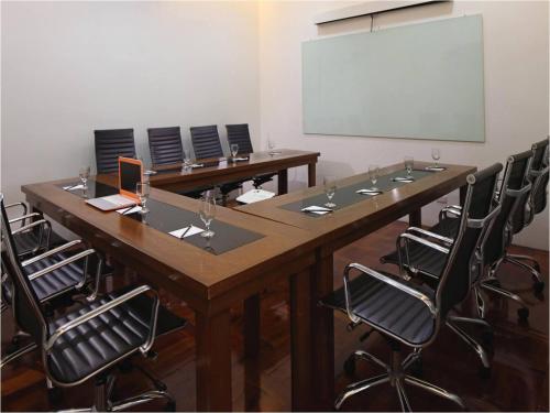 a conference room with a large wooden table and chairs at Manila Lotus Hotel in Manila