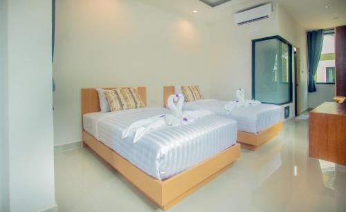 a bedroom with two beds with white towels on them at Saichon Grand View in Ban Lam Rua Taek