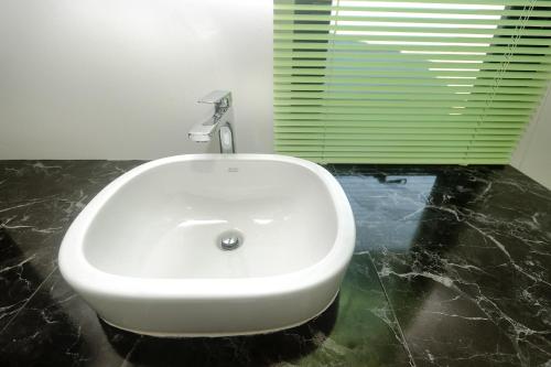 a white sink in a bathroom with a window at Saichon Grand View in Ban Lam Rua Taek