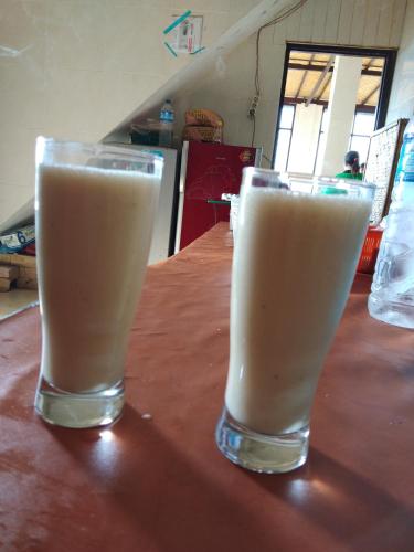 two glasses of milk sitting on a wooden table at Volcano Living in Kintamani