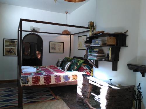 a bedroom with a bed and a shelf on the wall at Samira's Birds & Butterflies Park-Spashram Ganga Beach Retreat in Rishīkesh