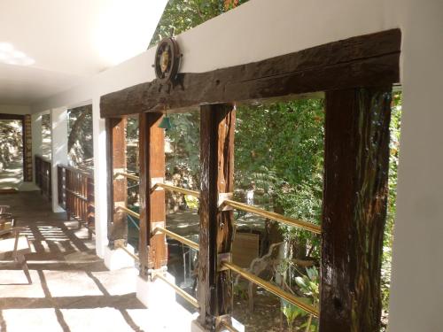 a window on the front porch of a house at Samira's Birds & Butterflies Park-Spashram Ganga Beach Retreat in Rishīkesh