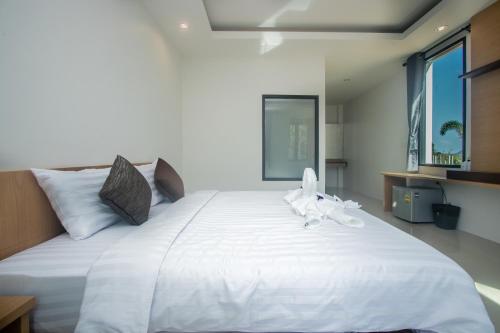a large white bed with white towels on it at Saichon Grand View in Ban Lam Rua Taek