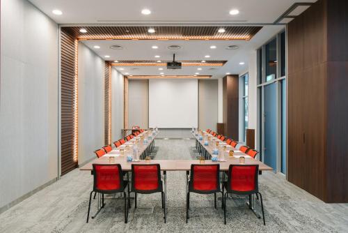 a large conference room with a long table and red chairs at Ibis Singapore on Bencoolen - Newly Renovated in Singapore