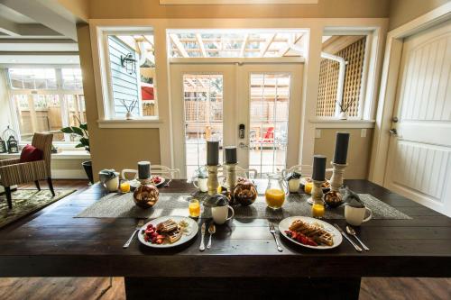 a table with plates of food on top of it at Kelowna Bed & Breakfast - CHATHAM HOUSE in Kelowna