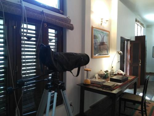 a camera on a tripod in a room with a desk at Samira's Birds & Butterflies Park-Spashram Ganga Beach Retreat in Rishīkesh
