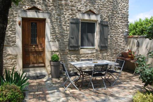 a table and chairs in front of a building at Le Mas des Clots in Upie