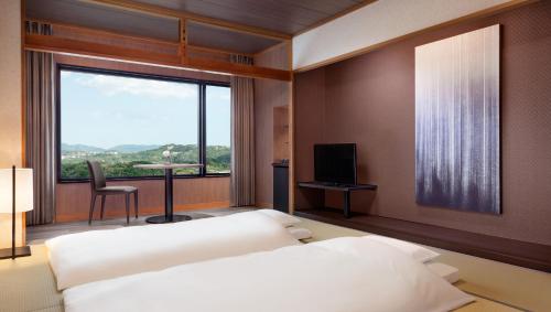 a bedroom with a bed and a large window at Nanki-Shirahama Marriott Hotel in Shirahama