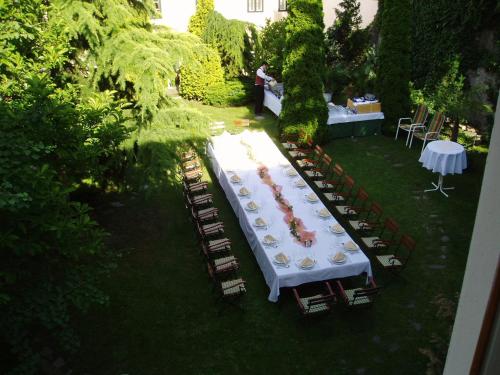 a long table with chairs and a white table cloth at Hotel Wollner in Sopron