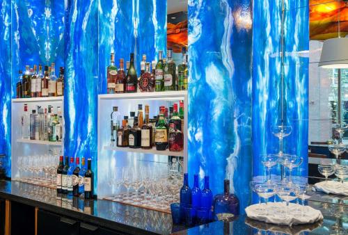 a bar with a blue curtain and bottles and glasses at Hyatt Place Portland Downtown - Old Port Square in Portland