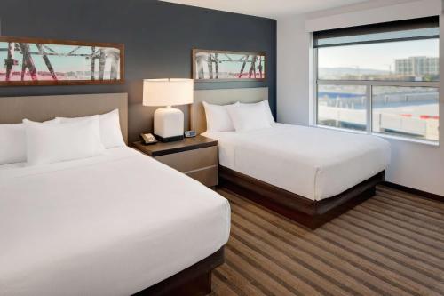 a hotel room with two beds and a window at Hyatt House Irvine/John Wayne Airport in Irvine