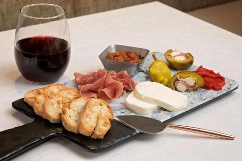 a plate with meat and cheese and a glass of wine at Hyatt House Irvine/John Wayne Airport in Irvine