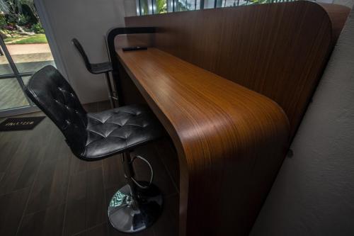 a desk with a black chair in a room at Saichon Grand View in Ban Lam Rua Taek