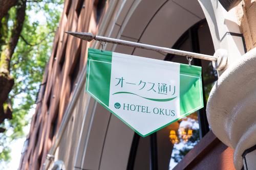 a sign hanging on the side of a building at Hotel Okus in Kumamoto