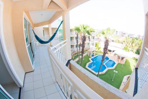 a balcony with a hammock and a view of a pool at Blue Beach Temporada in Aquiraz