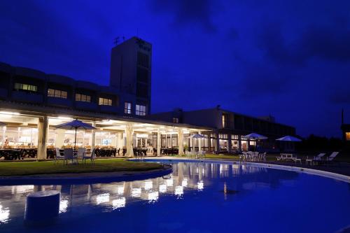 a building with a swimming pool at night at EN RESORT Kumejima EEF Beach Hotel in Kumejima