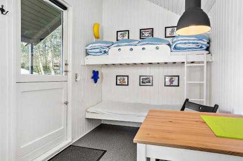 Omme Å Camping & Cottages في سونِر أوميه: غرفة صغيرة مع سرير بطابقين وطاولة
