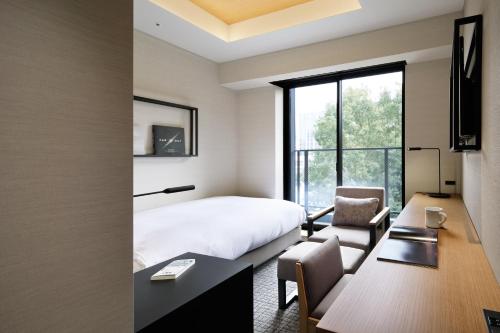 a hotel room with a bed and a desk and a chair at LAMP LIGHT BOOKS HOTEL nagoya in Nagoya