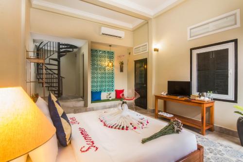 Una sala de estar con una escalera y un sofá. en Summer Bliss Boutique, en Siem Reap