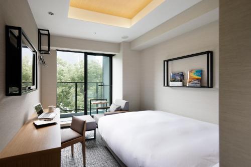 - une chambre avec un grand lit blanc et un bureau dans l'établissement LAMP LIGHT BOOKS HOTEL nagoya, à Nagoya