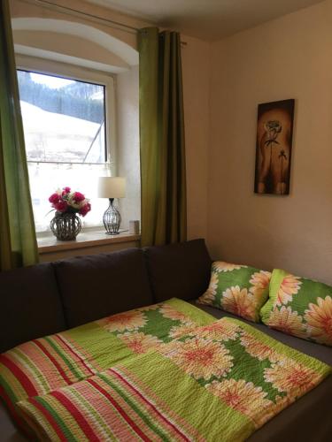 um quarto com um sofá e uma janela com um cobertor em Alpenaquarium Grüblsee - FEWO Monika em Vordernberg