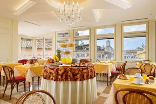 a dining room with tables and chairs and a chandelier at Hotel Bolivar in Rome