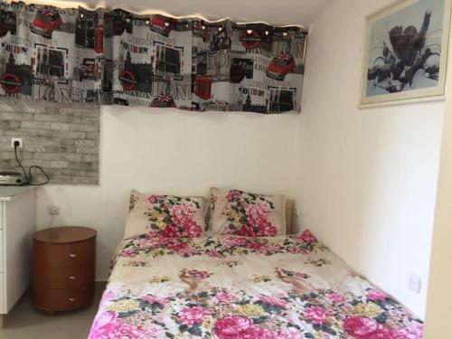 een slaapkamer met een bed met bloemen erop bij The Rosen's studio Place in Eilat