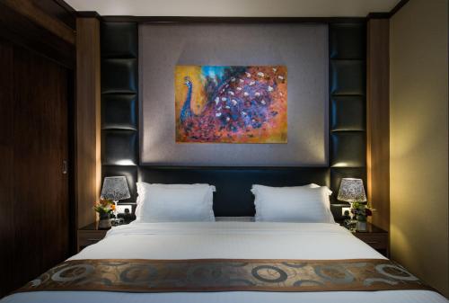 a bedroom with a bed with a painting on the wall at Mayan for service apartments in Riyadh