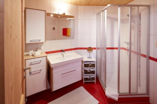 a bathroom with a white sink and a shower at Haus Sonnblick in Wangle