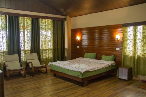 a bedroom with a bed and two chairs at The Barfung Retreat in Gangtok