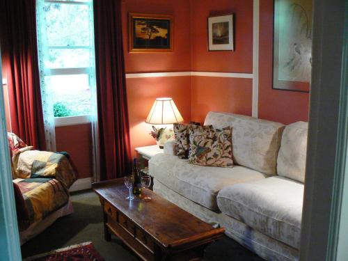 a living room with a couch and a coffee table at Lemon Tree Cottage in Leura
