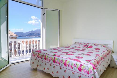 a bedroom with a bed and a large window at Apartments - IRINA in Sveti Stefan