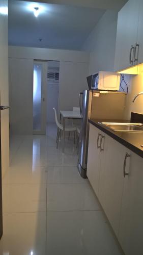 una cucina con lavandino e tavolo in una stanza di Studio Deluxe Apartment in Princeton Residences a Manila