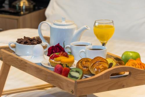 a tray of breakfast foods and a glass of orange juice at Mayan for service apartments in Riyadh