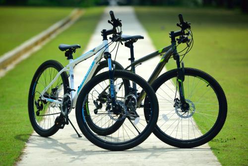 two bikes parked next to each other on a sidewalk at Pantai Indah Lagoi Bintan in Lagoi