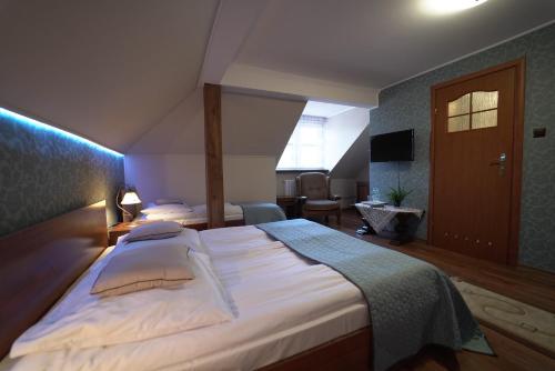 Una cama o camas en una habitación de Dworek Biała Dama