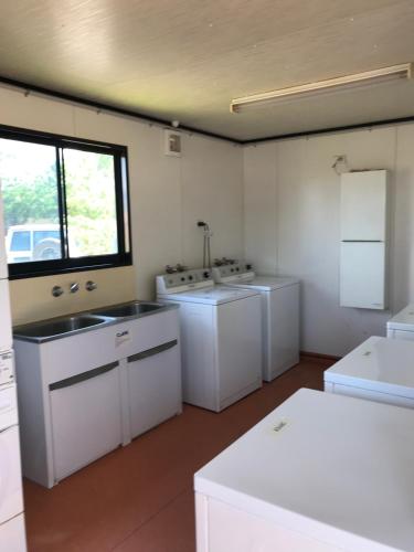 uma grande cozinha com electrodomésticos brancos e uma janela em Karratha Lodge TWA em Karratha