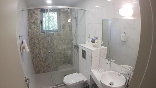 een badkamer met een douche, een toilet en een wastafel bij Villa White Lagoon in Topola